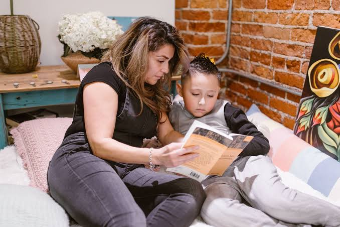 A mother and child reading a book together
